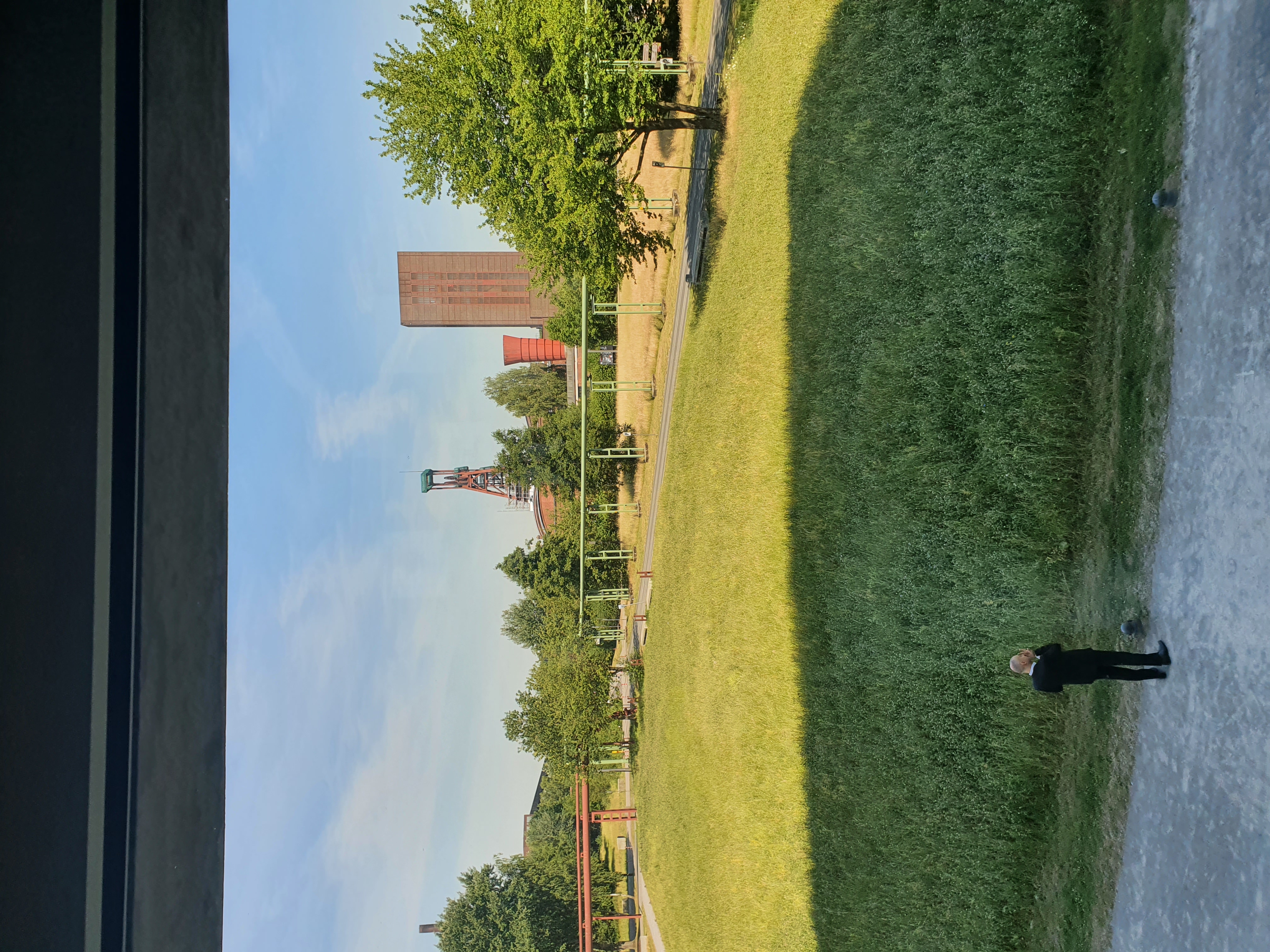 Foto aus dem Veranstaltungsgebäude, es ist eine Wiese und im Hintergrund Gebäude des Weltkulturerbes Zollverein zu sehen